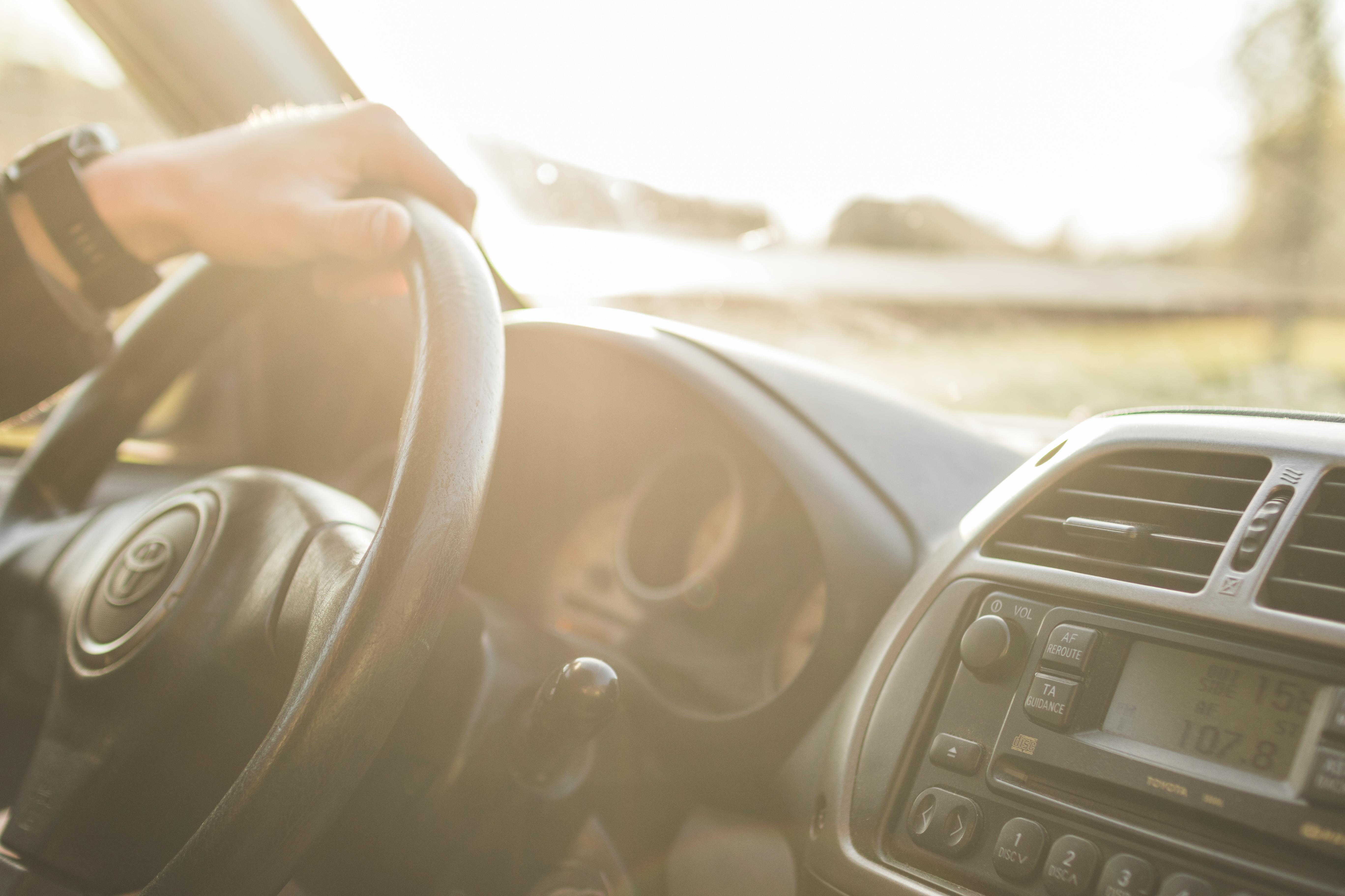 Close up photography of man holding car wheel and driving