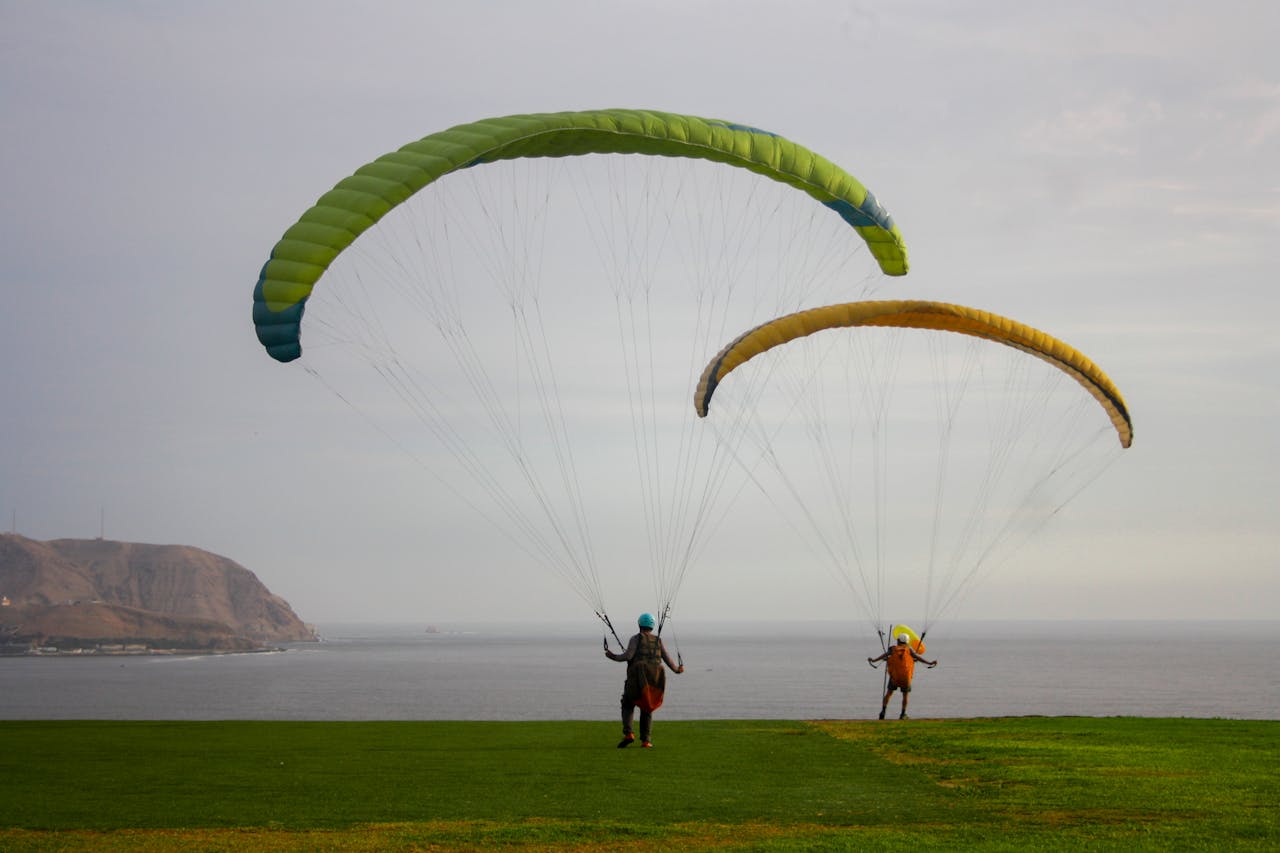 People with Parachutes Landing on Seashore