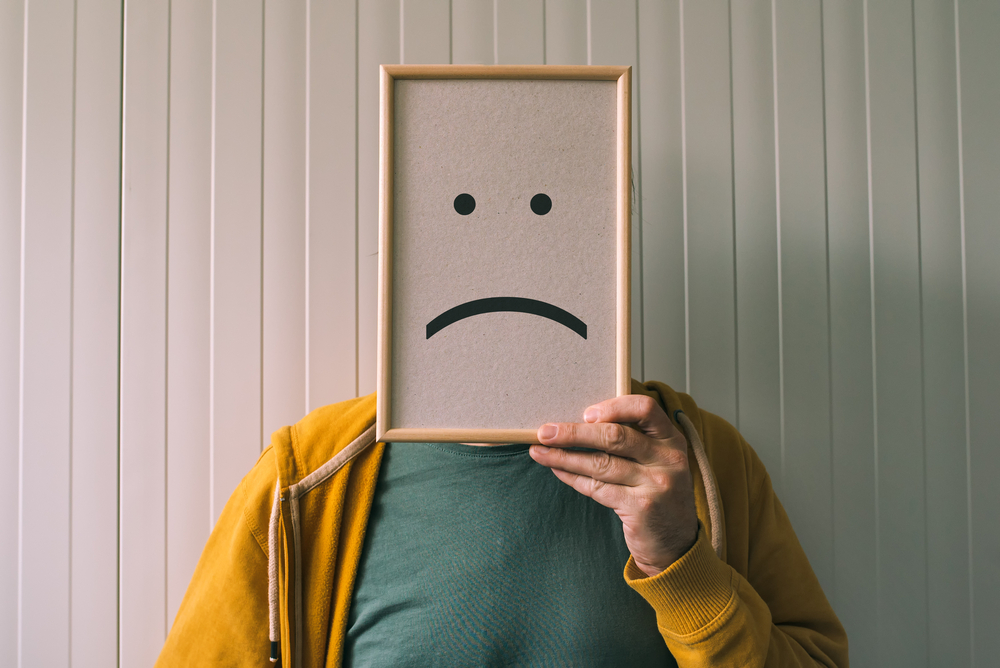 man holding picture frame with smiley emoticon printed.