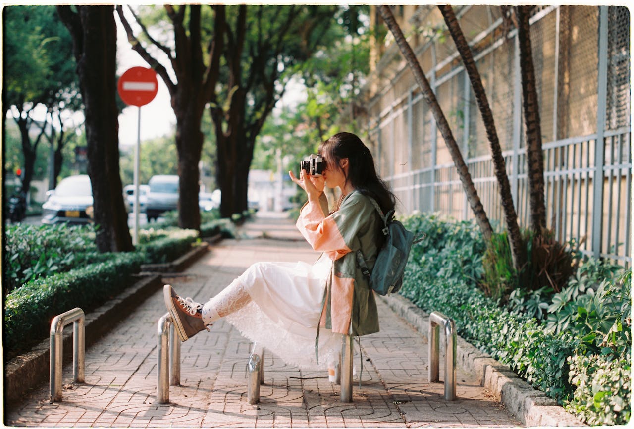 Woman Taking a Picture on a Sidewalk in City