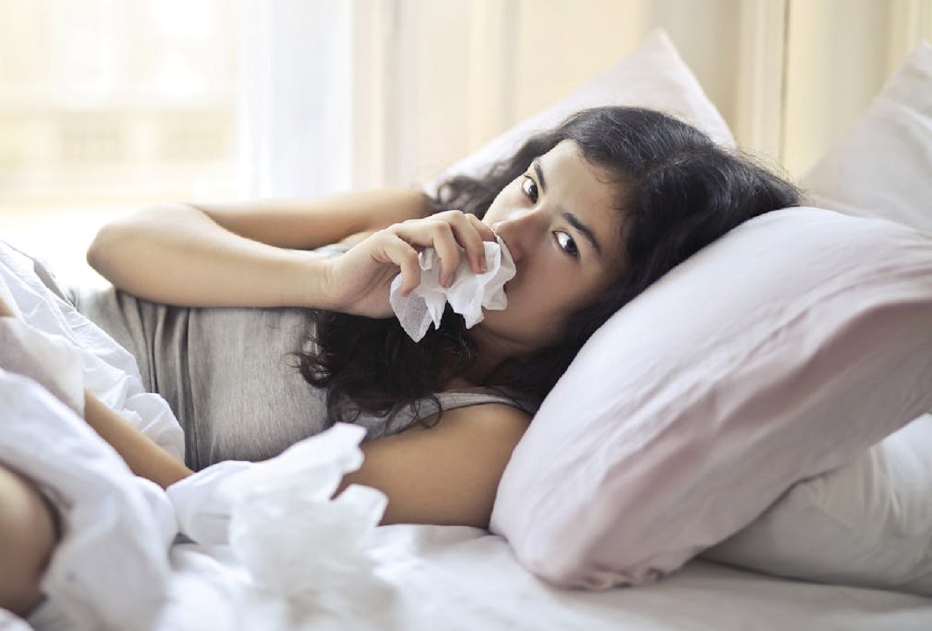 Woman Lying on Bed While Using Tissue