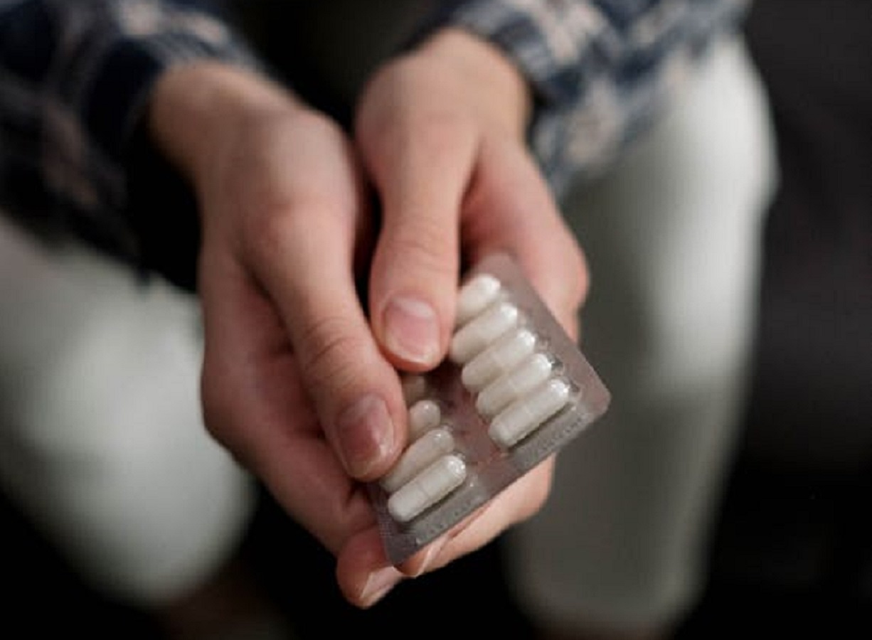 Person Holding White Medicine Capsules