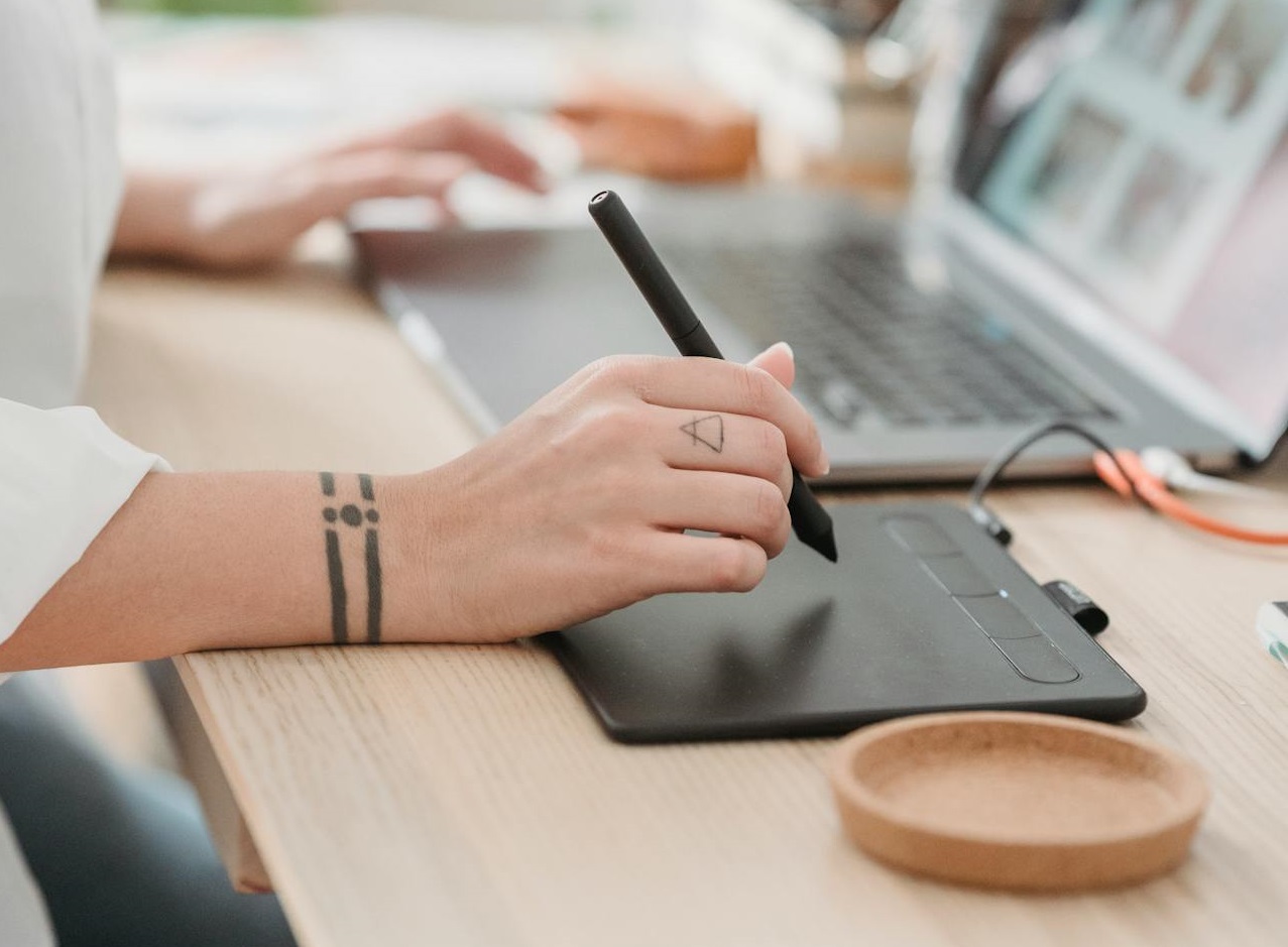 Woman working on laptop and graphic tablet