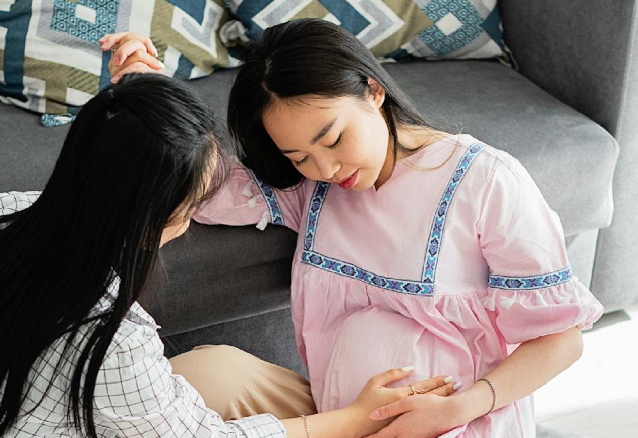 Women Keeping Hand on Pregnant Belly of Friend