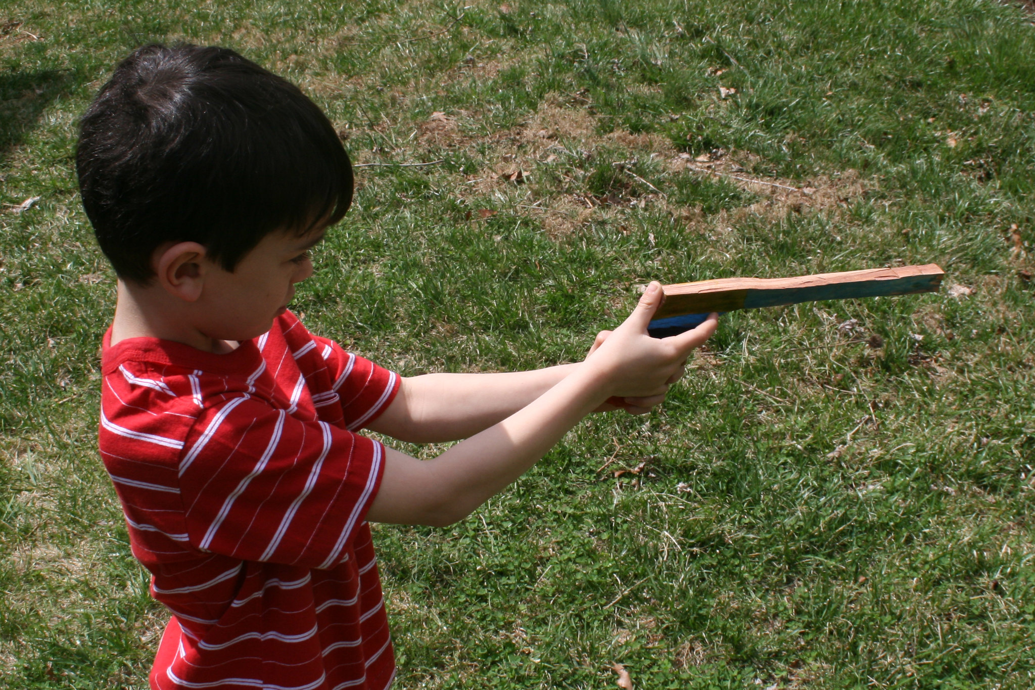 Boy with toy wooden gun.