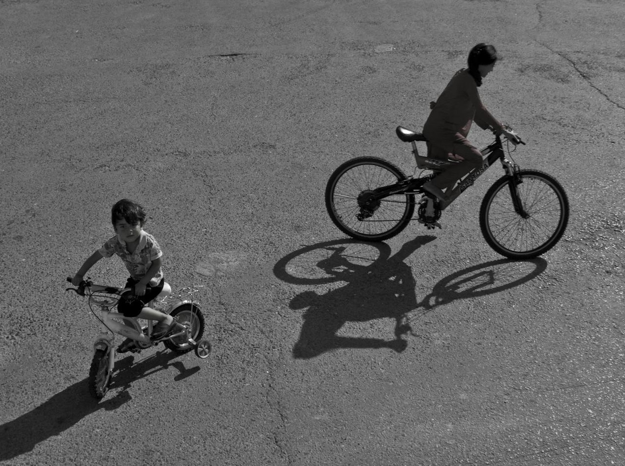 Greyscale Photo of Two Boys Riding Bicycles