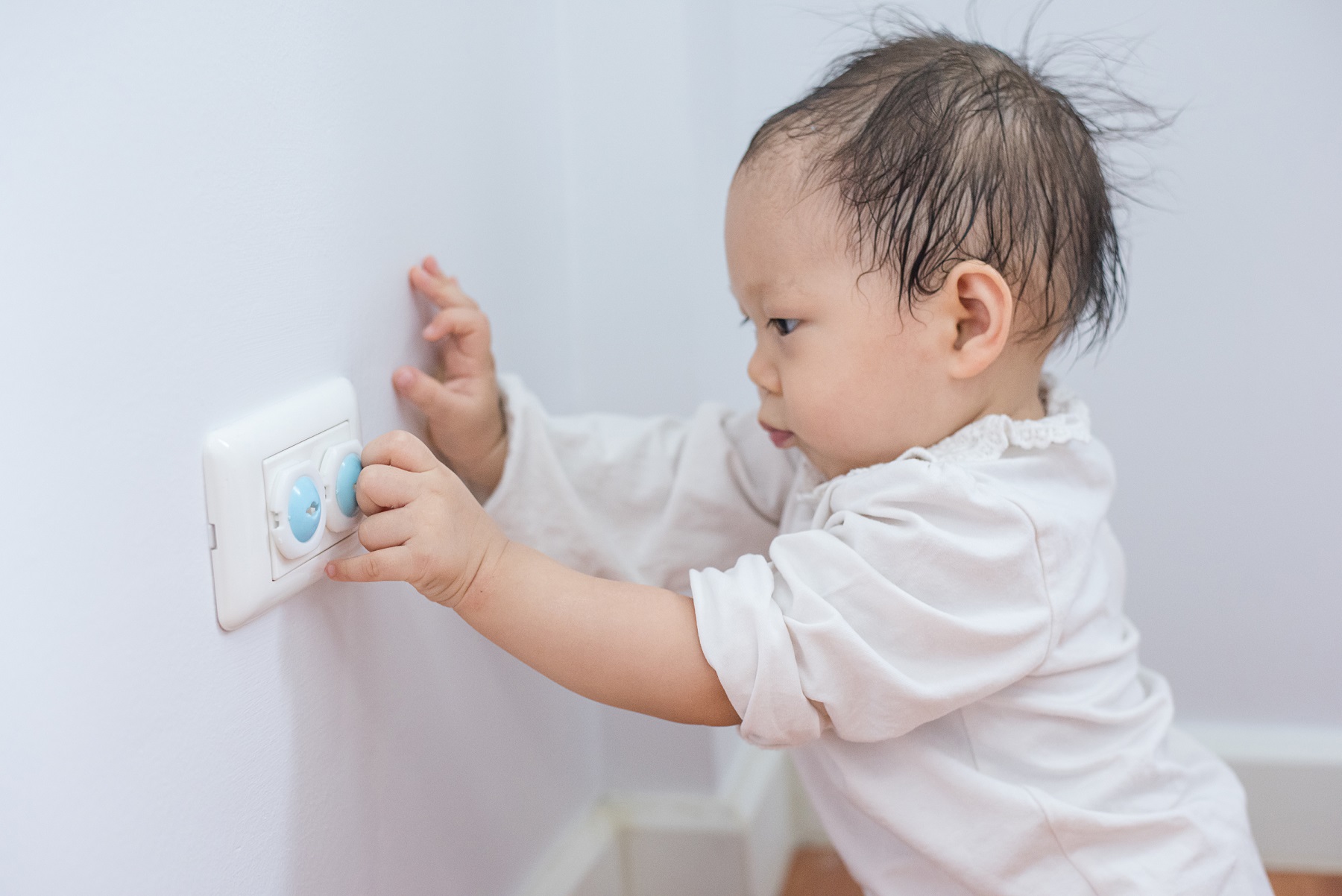 Curious little boy playing with electric plug.