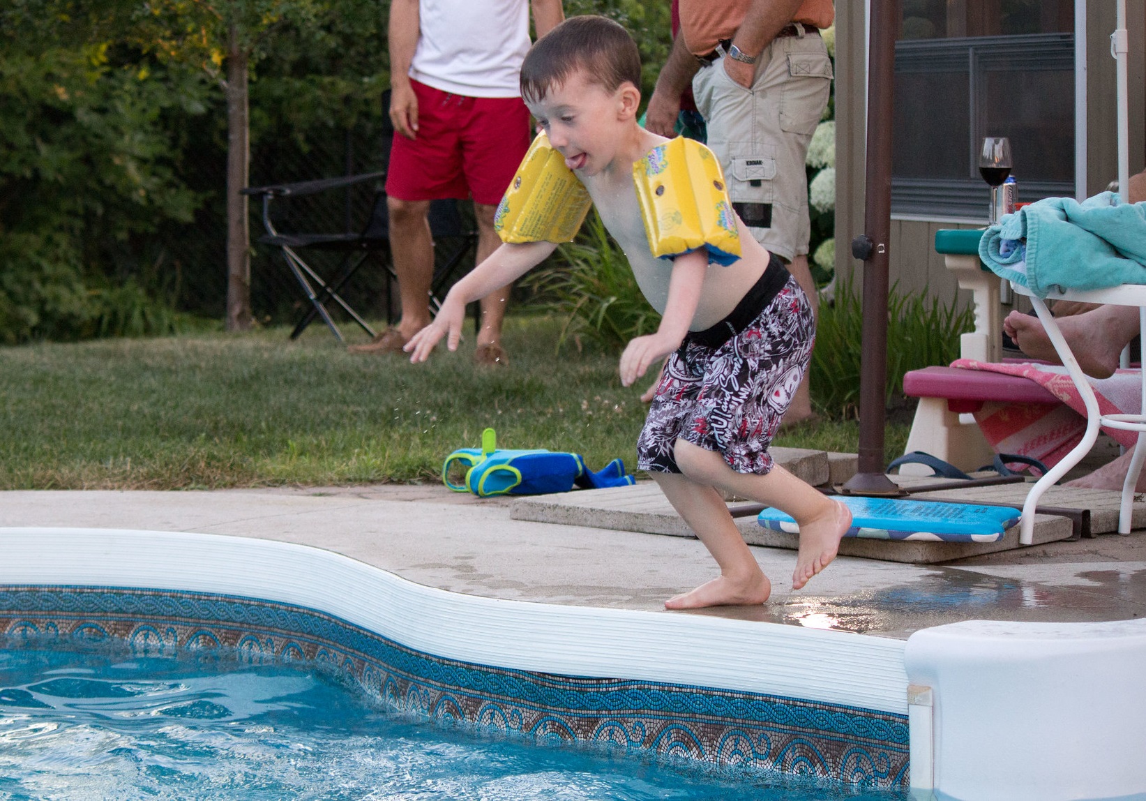 Kid id jumping in to pool.