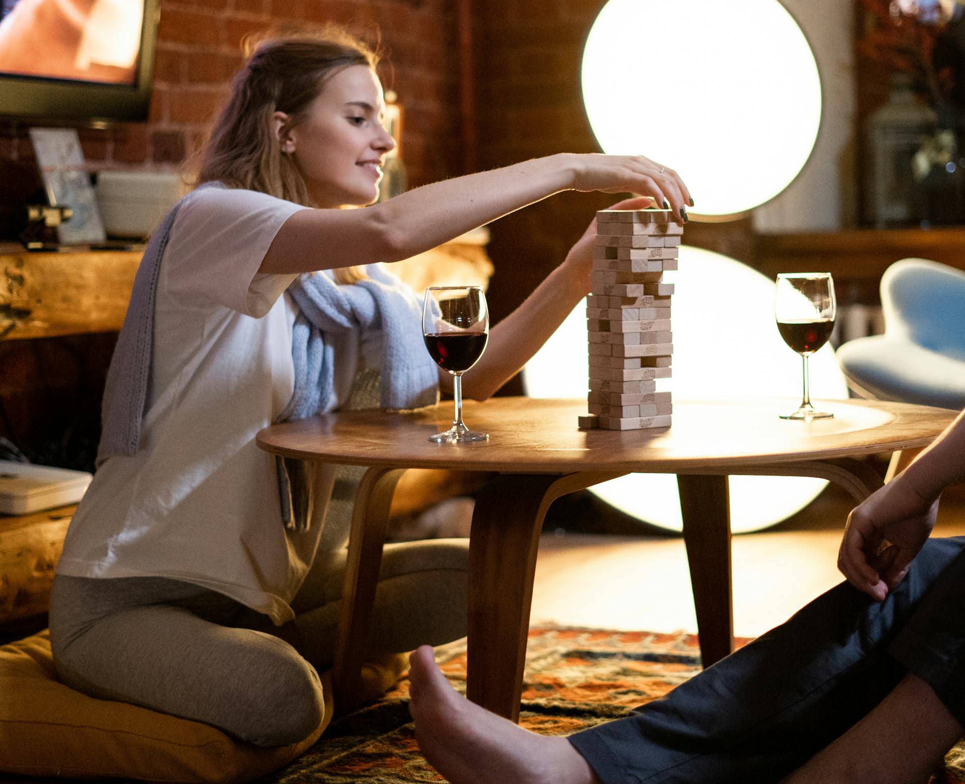 image of a woman in white shirt and man drinking wine and playing game