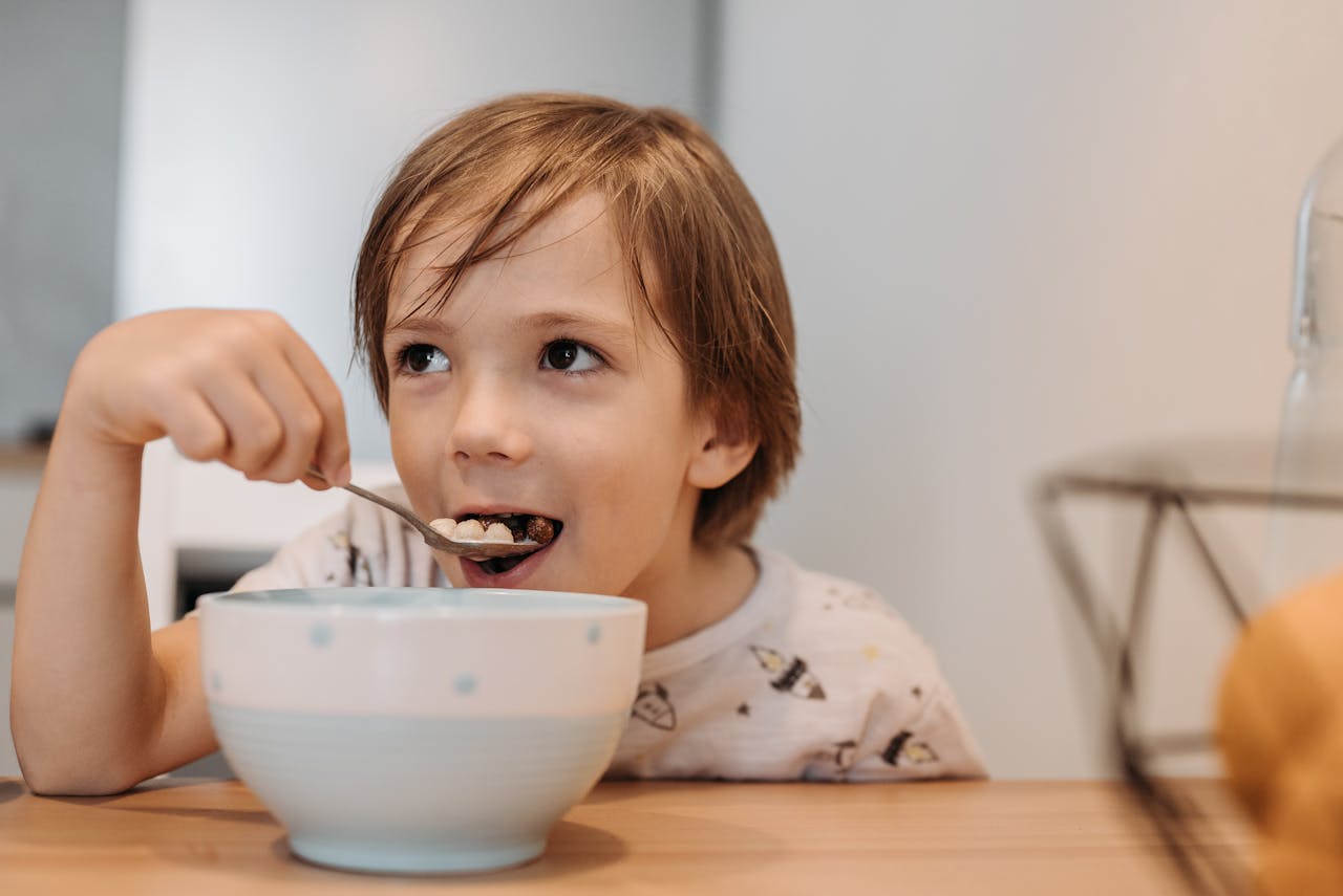 Boy Eating Cereals on the table.