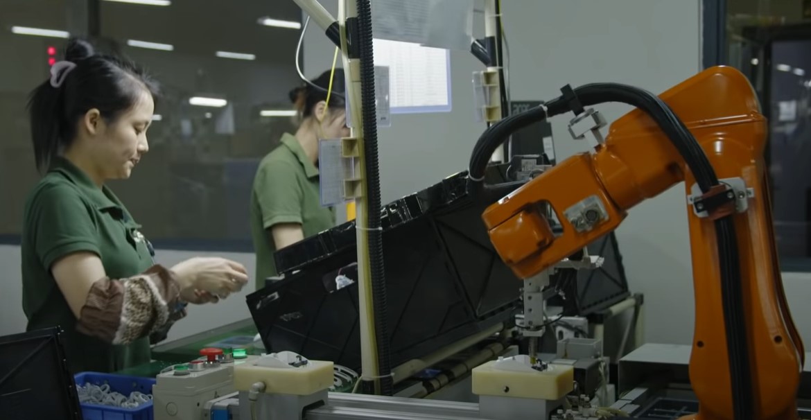 image of a woman working in a factory with robots