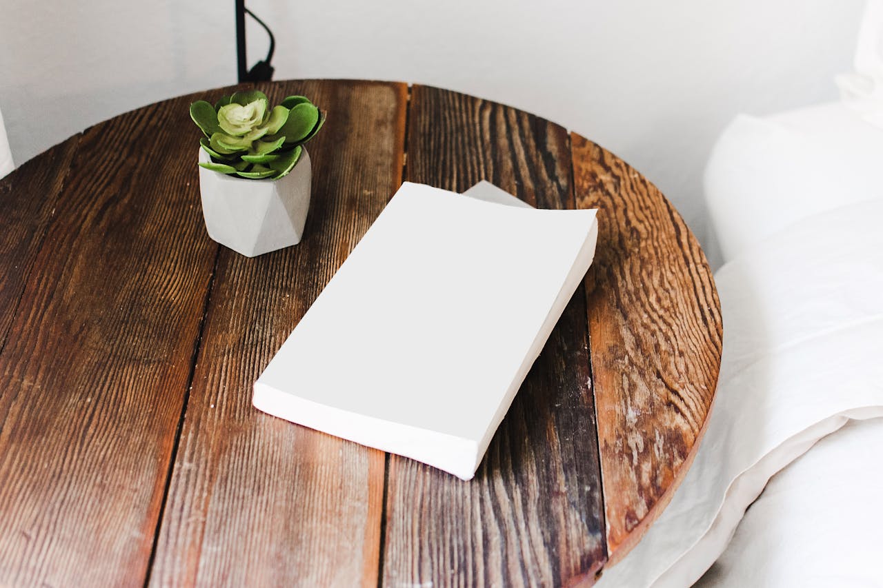 image of a wooden table with white book on it