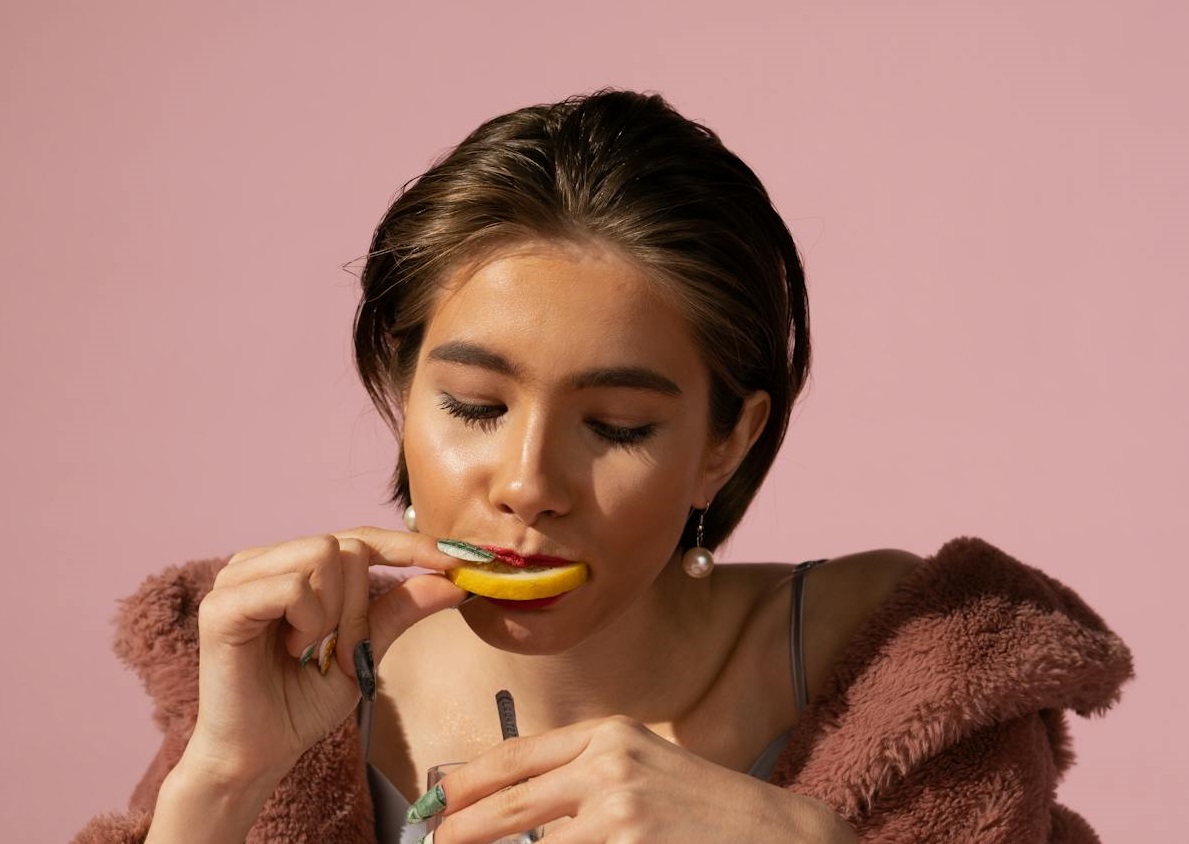 Woman Eating a Slice of Lemon