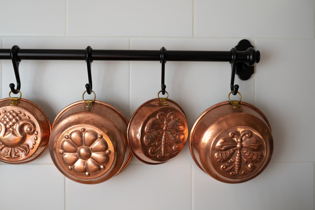 Copper Baking Pans Hanging on Wall in Kitchen