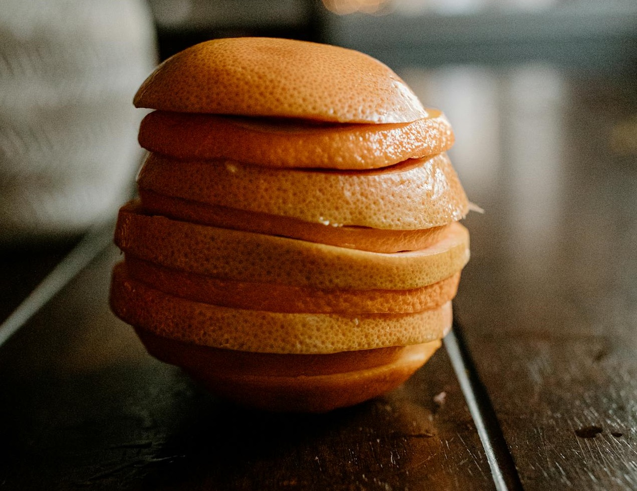 Slices grapefruit on wooden table near plant