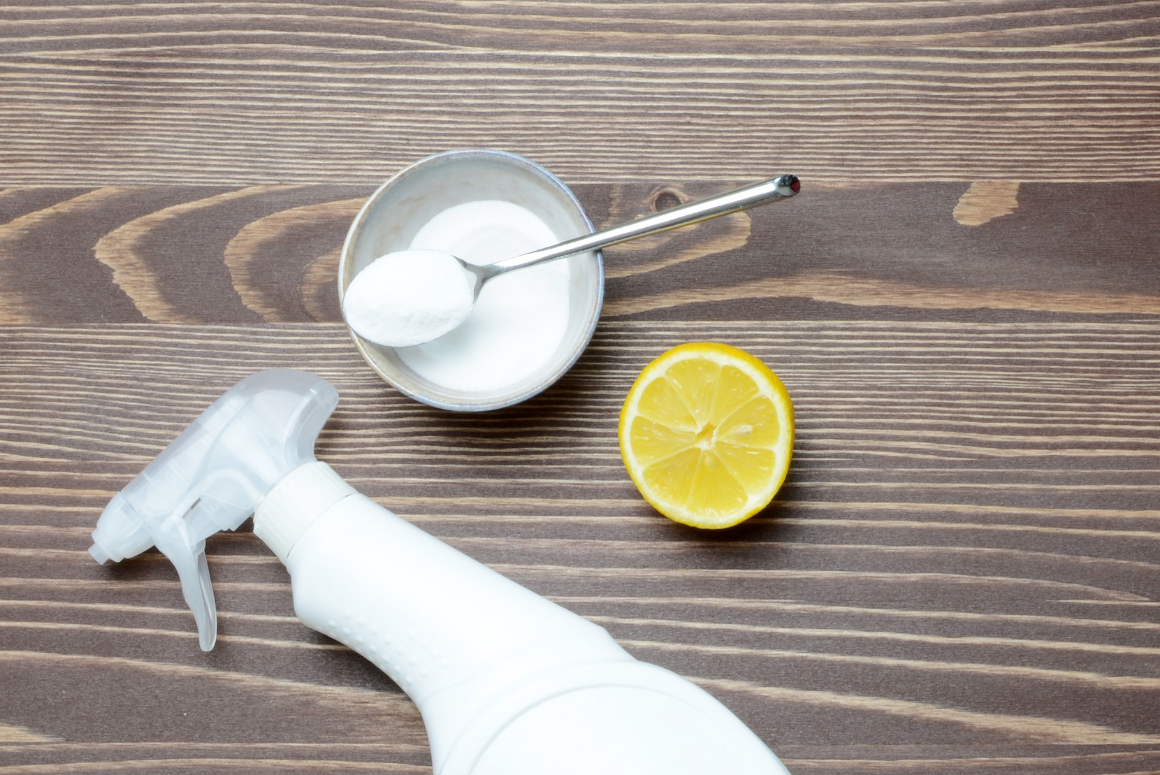 Eco friendly natural cleaners baking soda, lemon, salt and vinegar on a wooden backbround.
