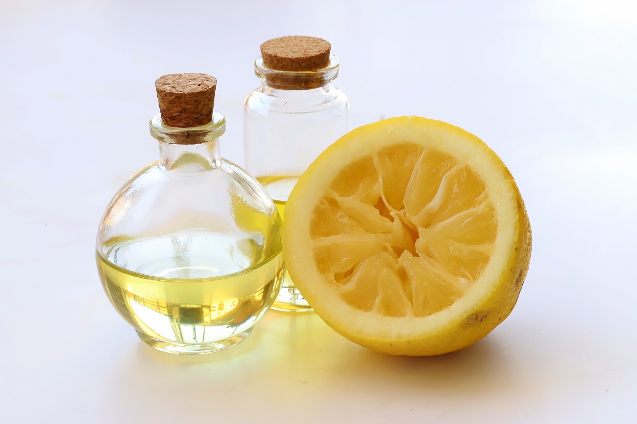 Lemon and lemon peel oil on white background