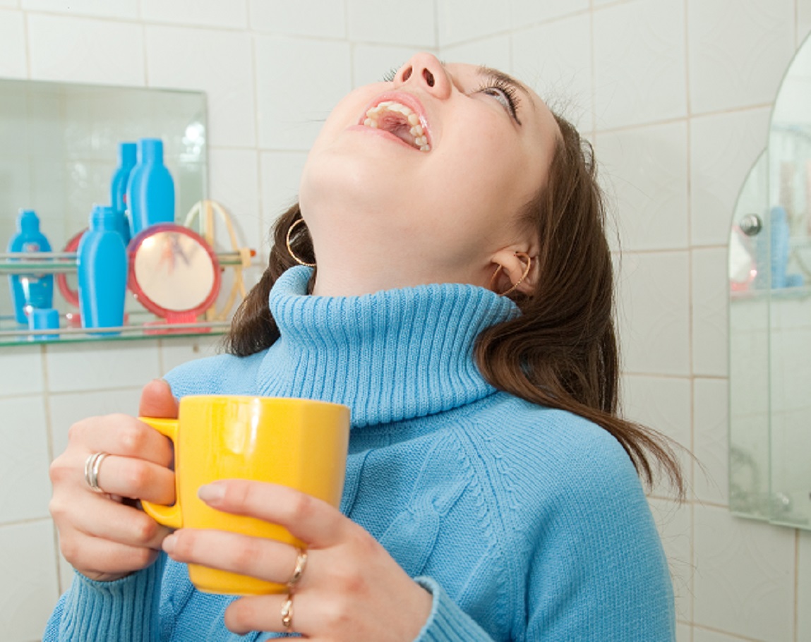 Brunette illness girl gargles her throat in bath