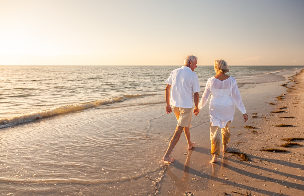 Happy senior man and woman old retired couple walking and holding hands