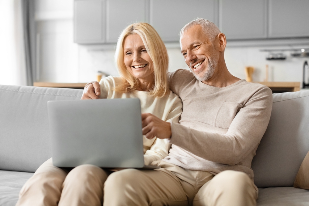 Older couple enjoying time together, looking at a laptop screen