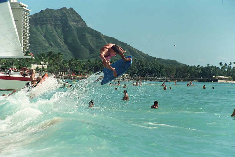 Surfer with his board in the air at Waikiki Beach, Hawaii.