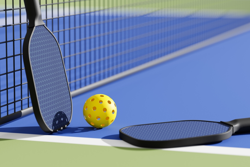 ickleball sport equipments, paddles and basket of balls on court