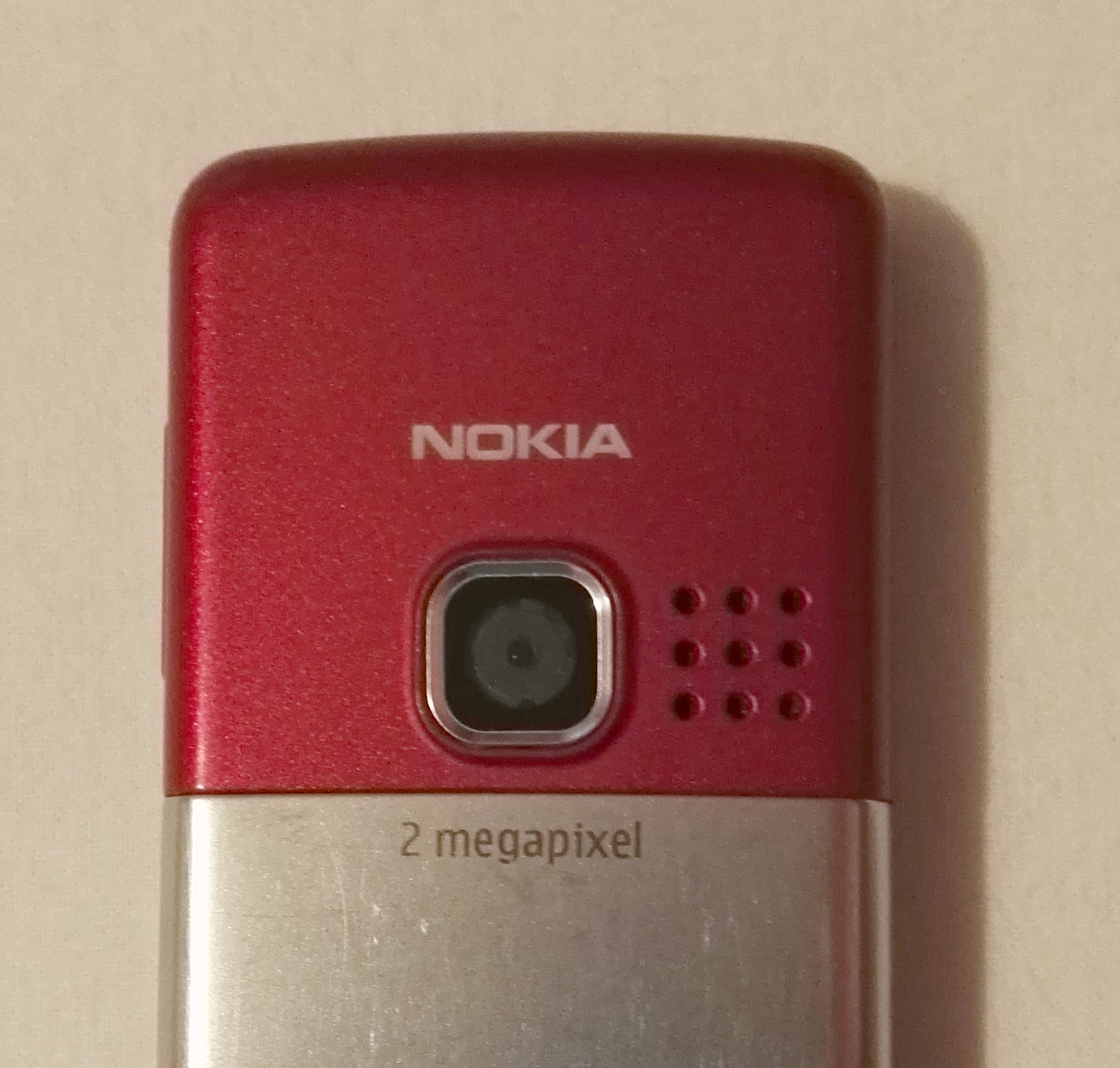 Back view of red Nokia 6300 cell phone.