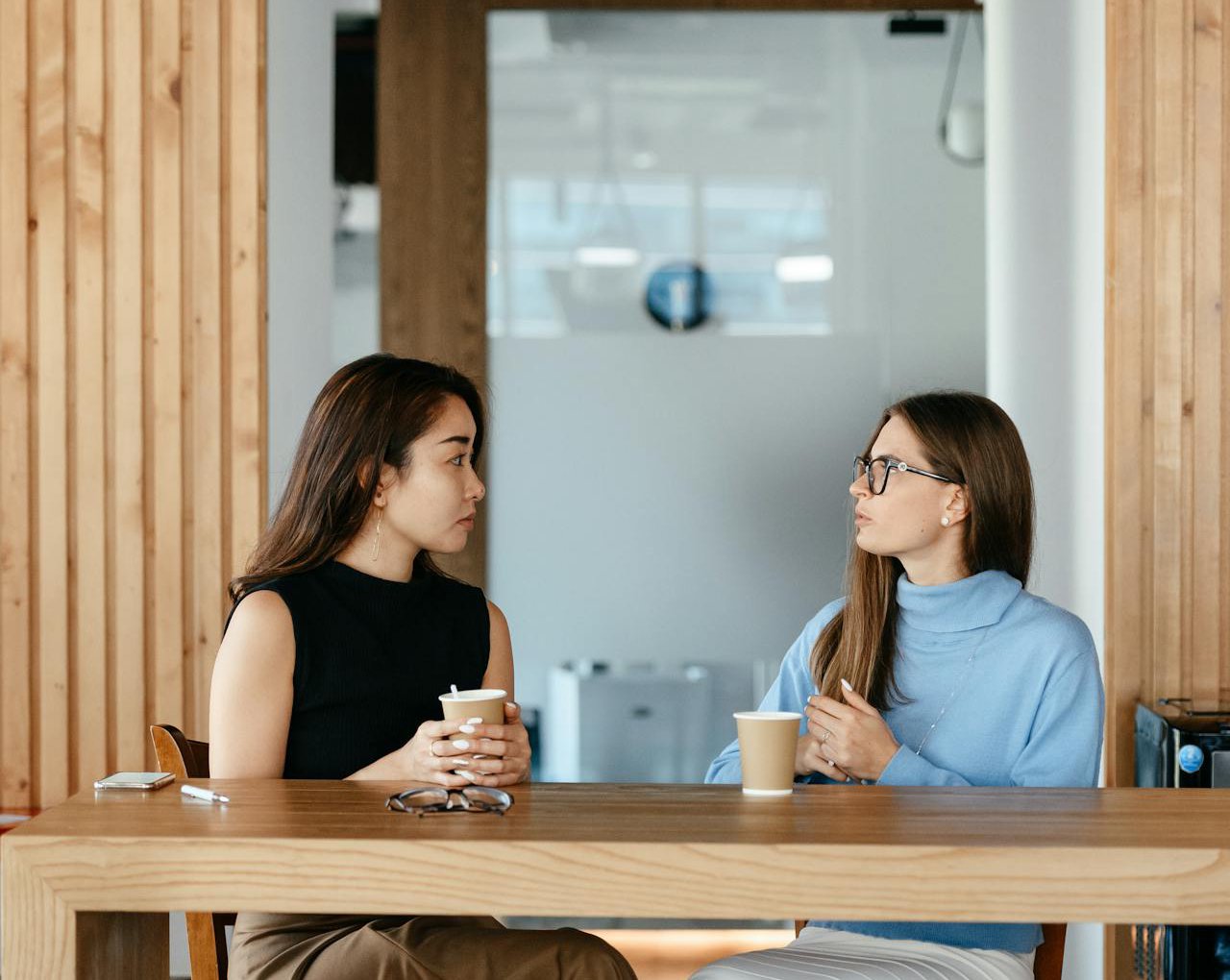Serious businesswomen discussing job during coffee break