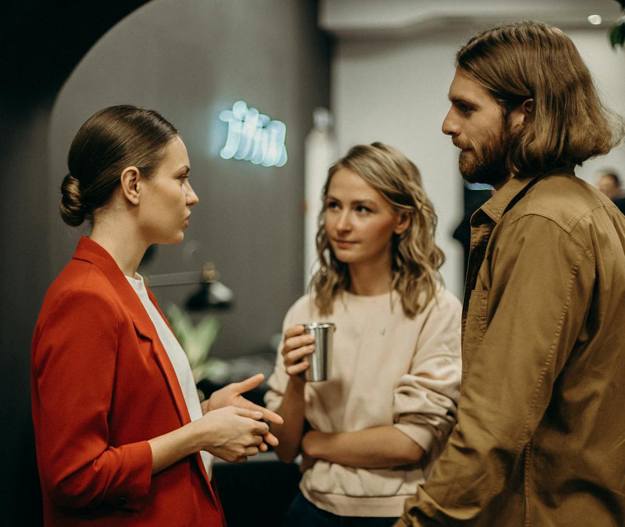 Portrait Photo of Two Women and Man Talking