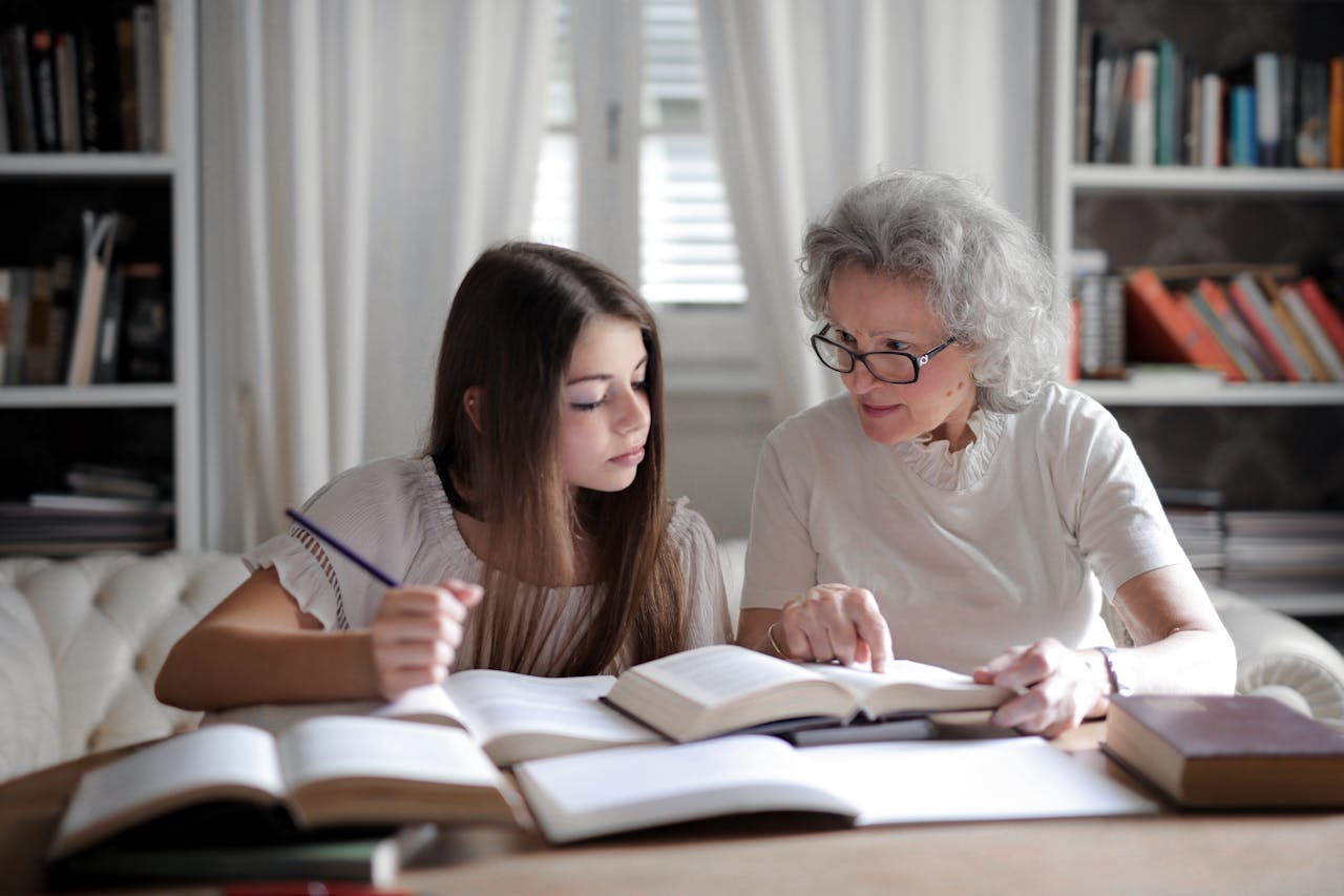 Photo of Woman Talking to a Girl while sitting on a table
