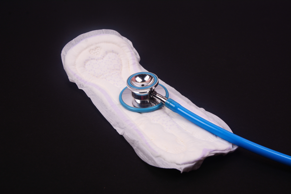 A blue stethoscope on white sanitary pad