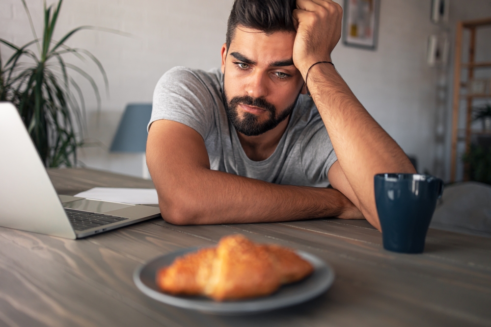 man looking at his breakfast with no desire to eat