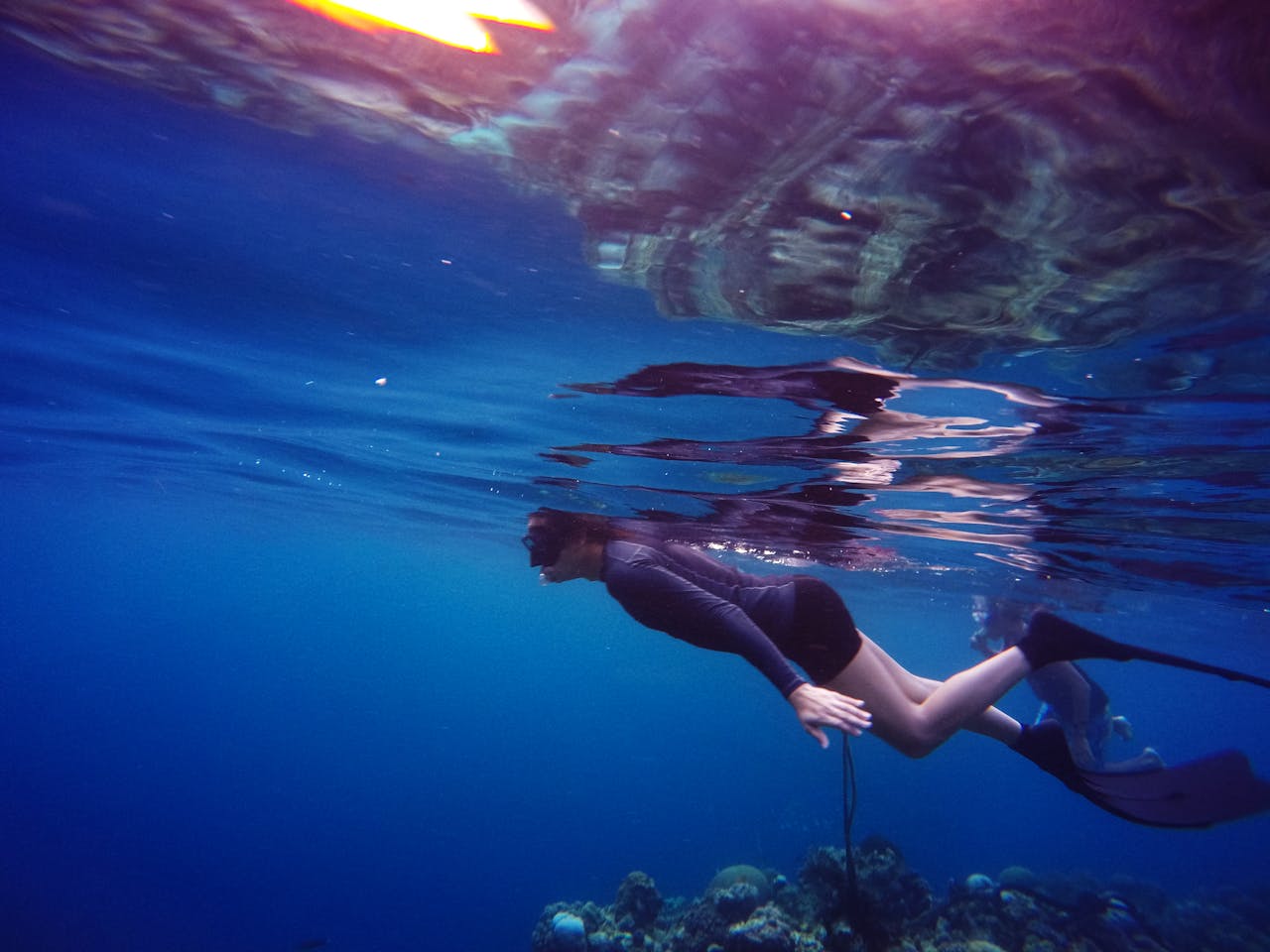 Woman In Scuba Gear Swimming Under Water