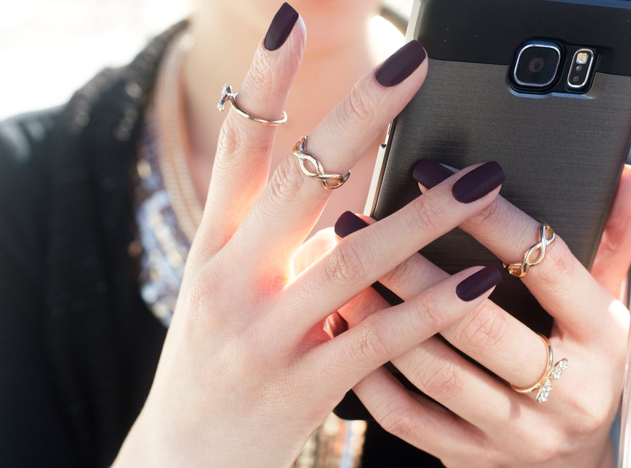 woman holding phone close up image of her hands