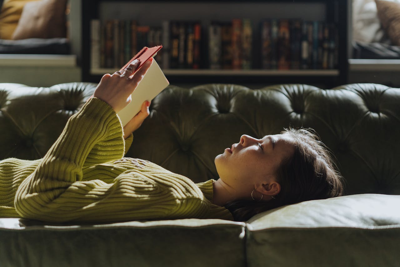 Woman Lying on Couch and reading a book