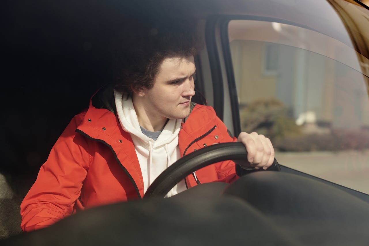 boy in Red and White Hoodie Driving a Car