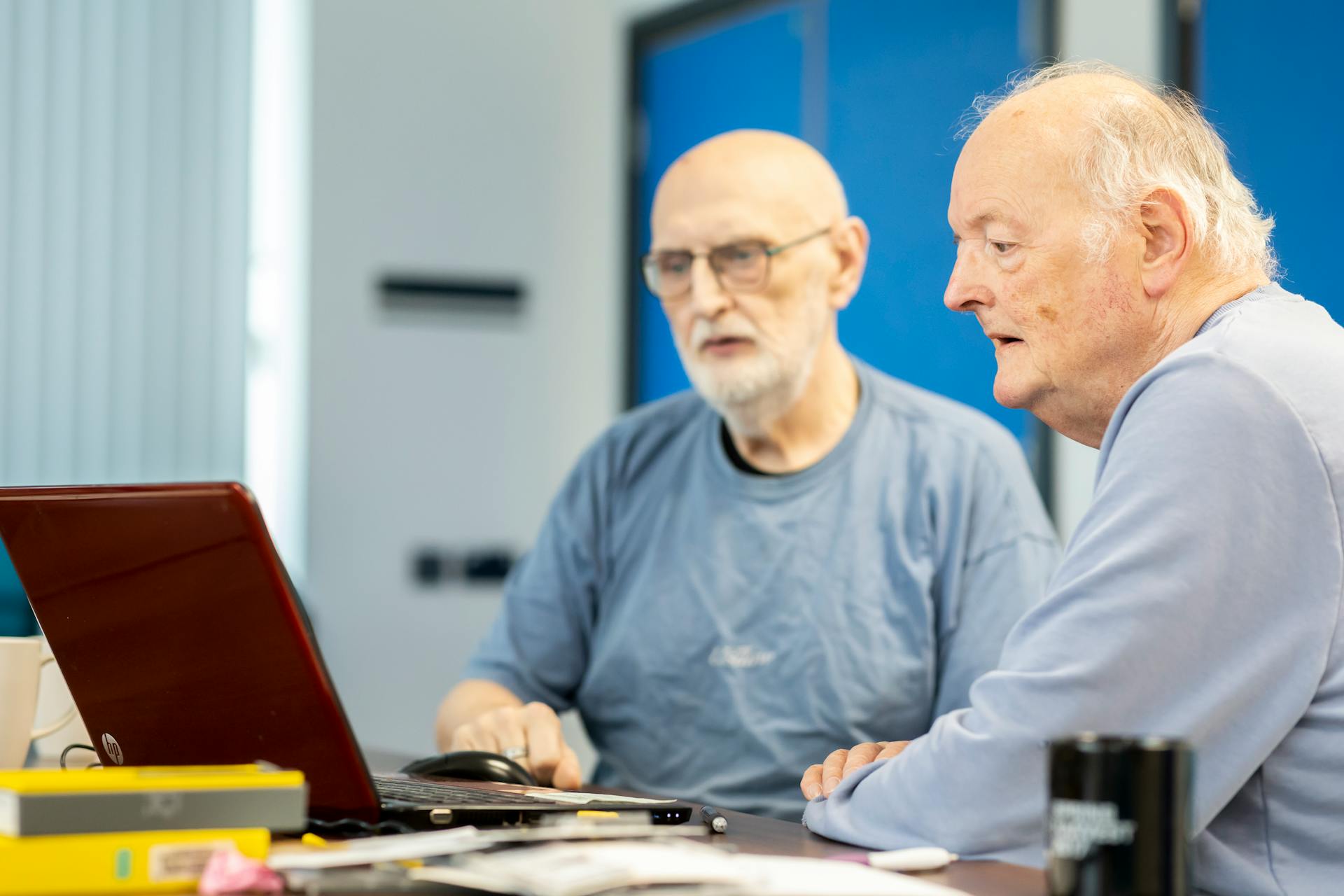 Elderly Men Sitting at Desk with Laptop