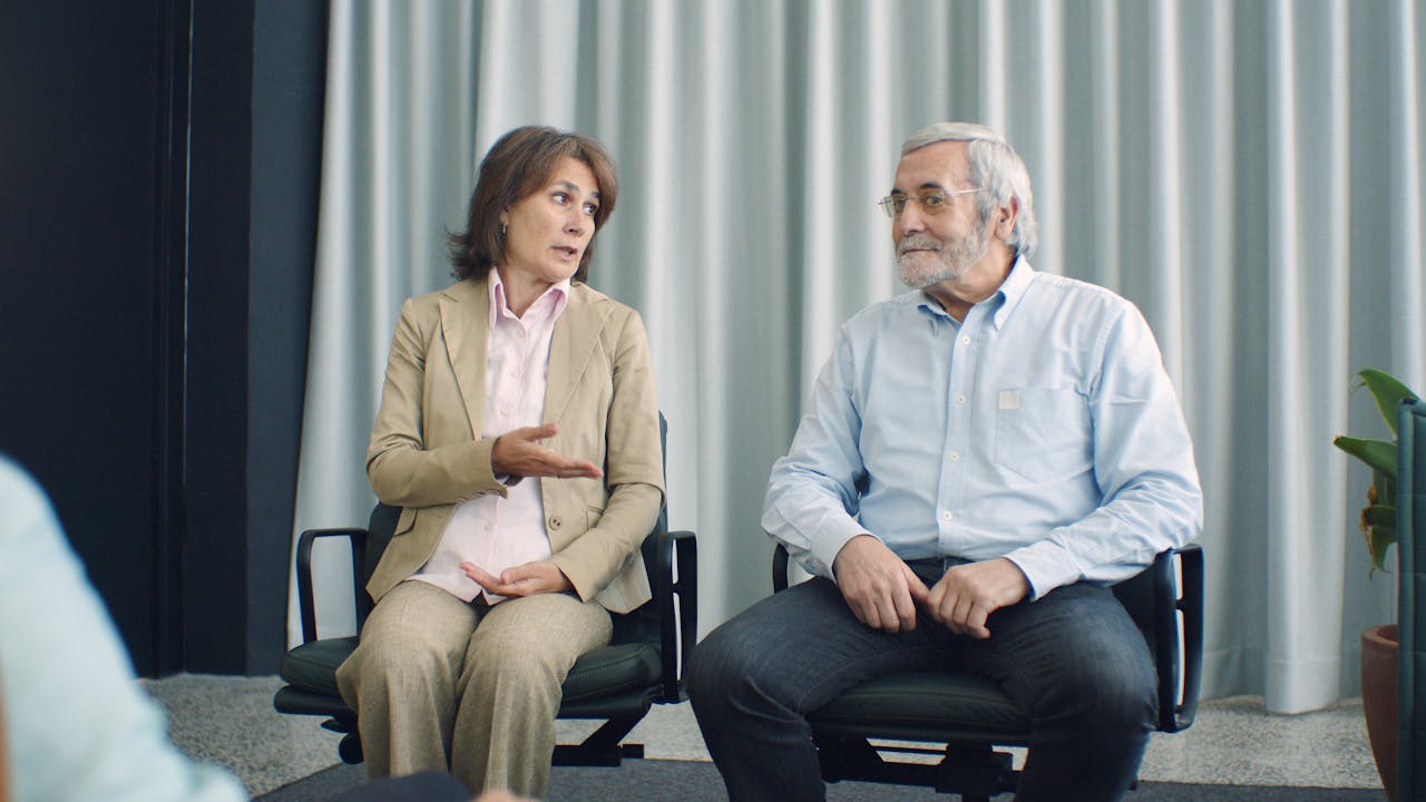 Elderly Couple sitting in a n office talking to each other