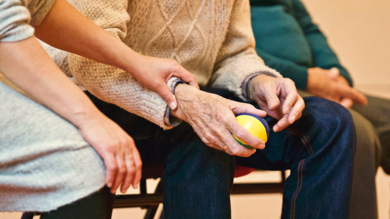 Close Up Photo of Person Holding a Stress Ball while other holds his hand