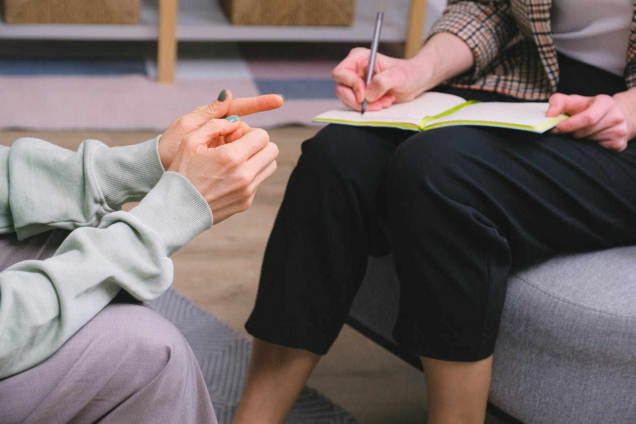 Anonymous female therapist and client sitting in armchairs