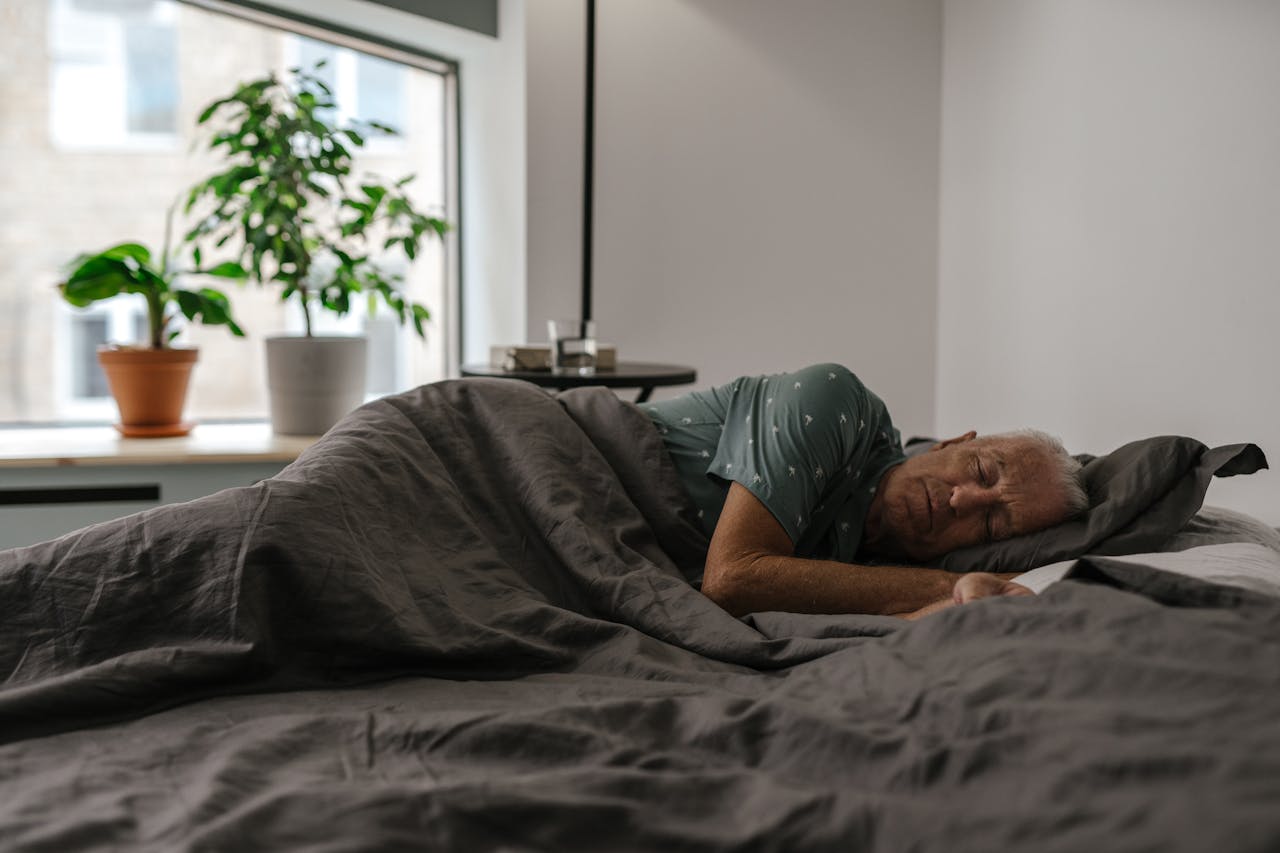 Portrait Photo of An Elderly Man Sleeping on Bed