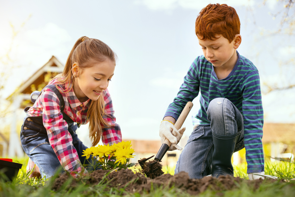 kids planting flowers while being together