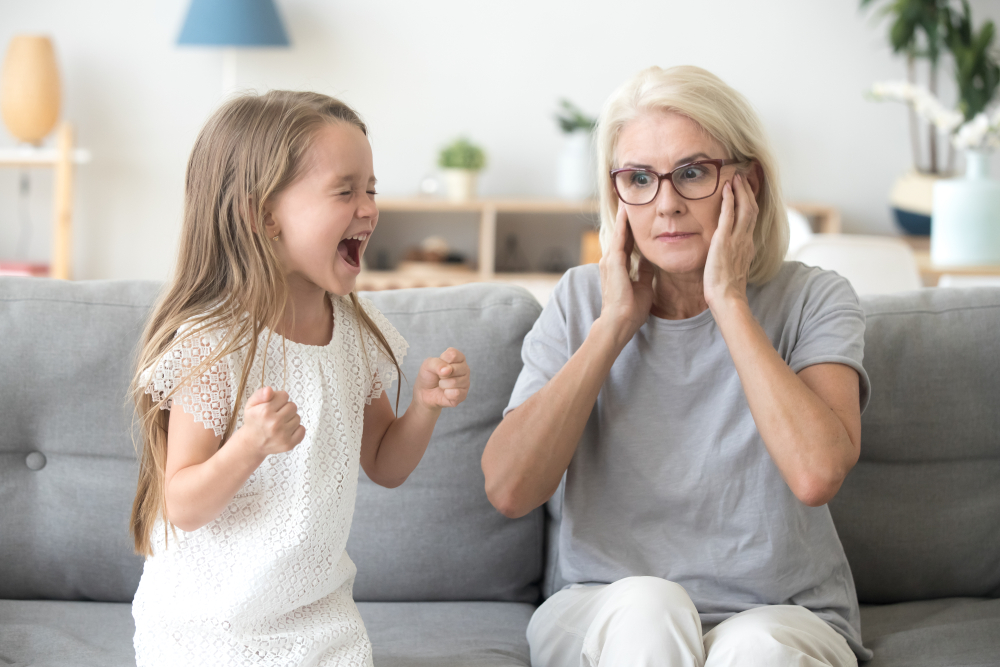 grandma closing ears not to hear noisy granddaughter