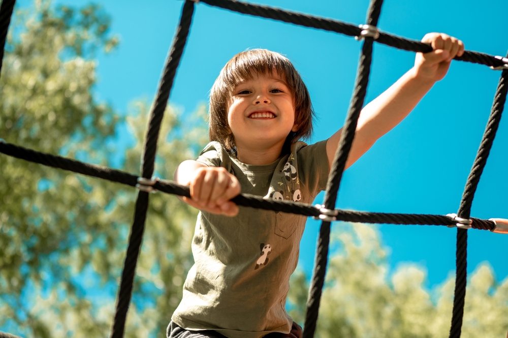 A child climbs up an alpine grid