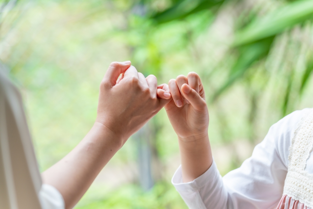 two people crossing little finger together