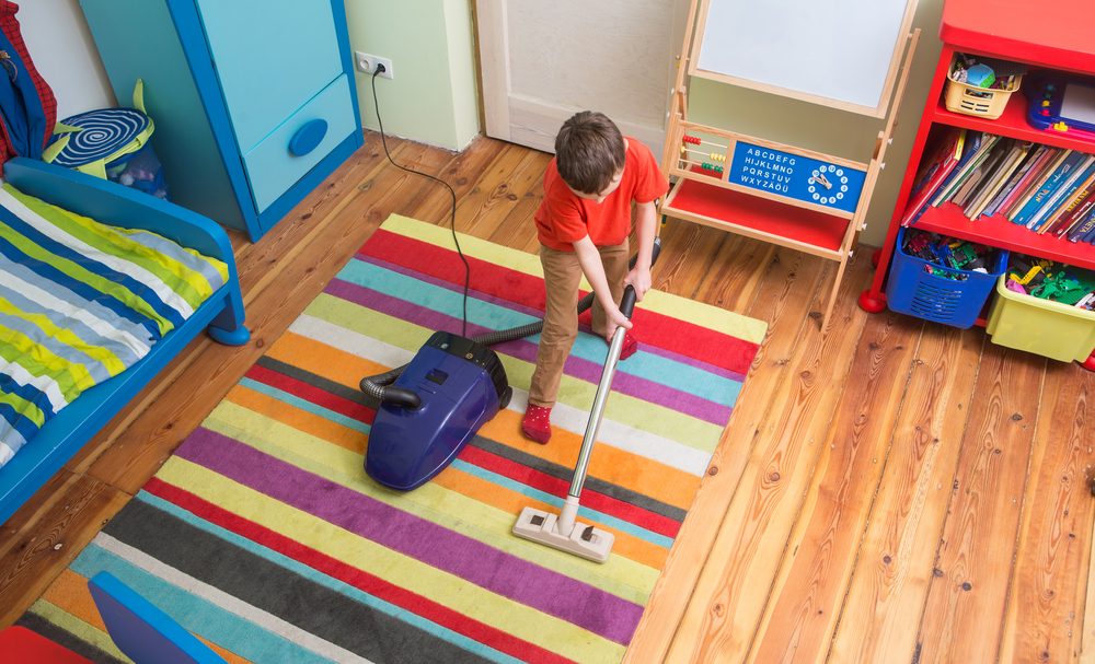 boy cleaning floor with hoover