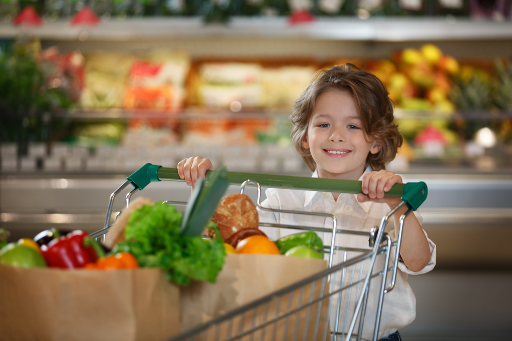 Little cute boy with shopping cart