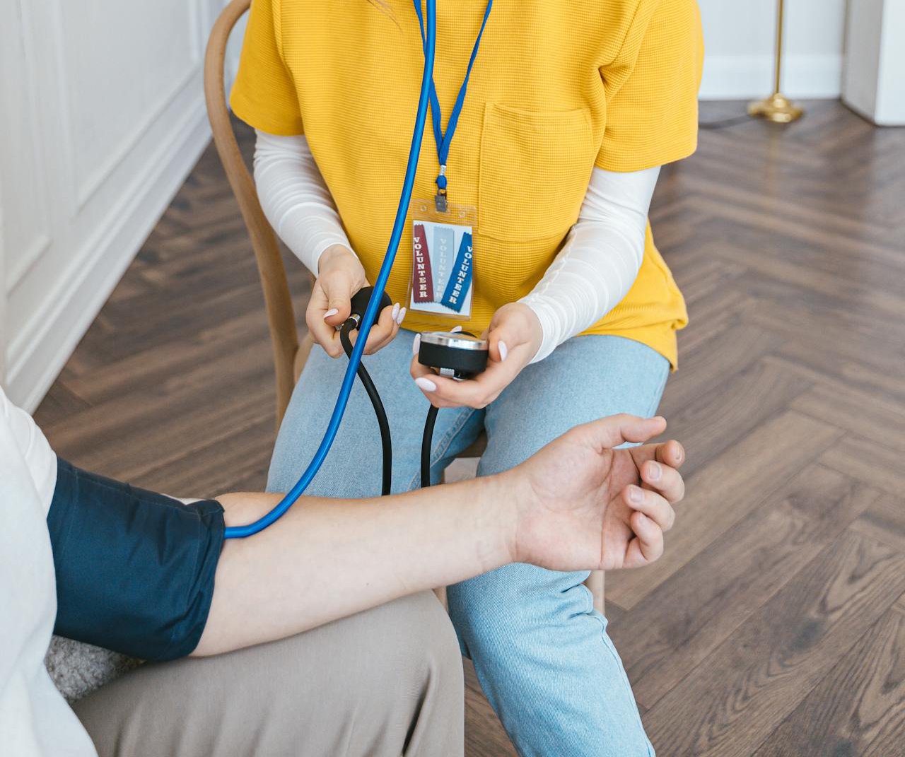 Photo of Woman Measuring Pressure with Device to another person