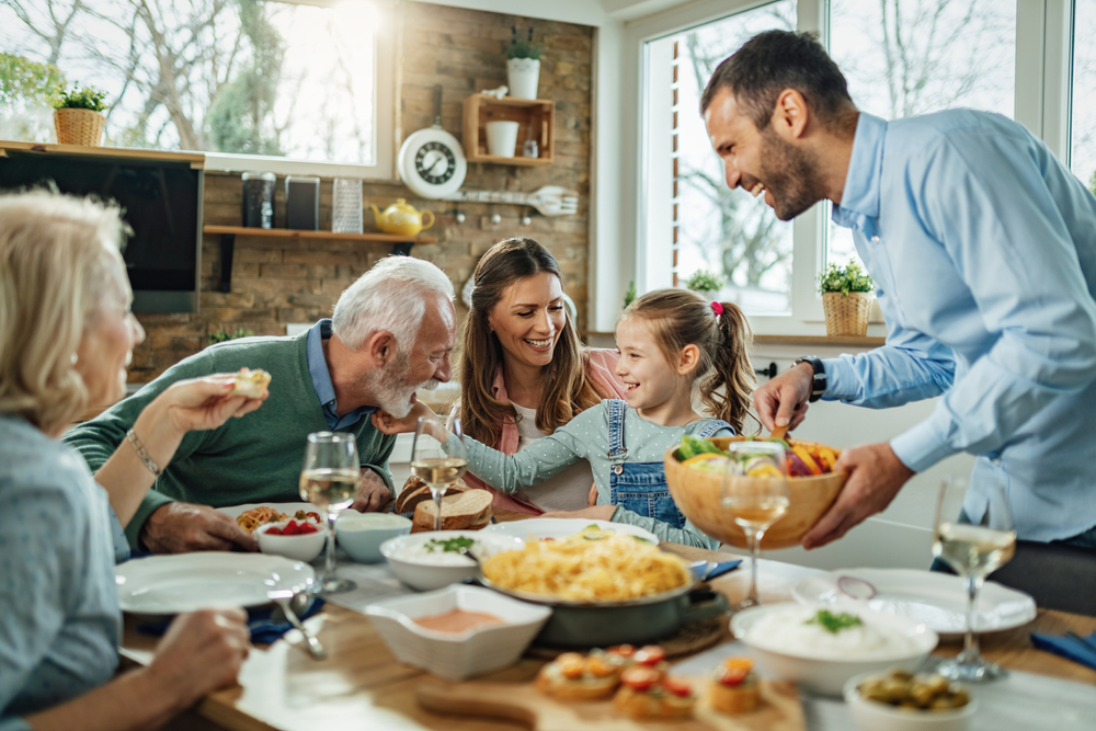 Happy multi-generation family gathering around dining table