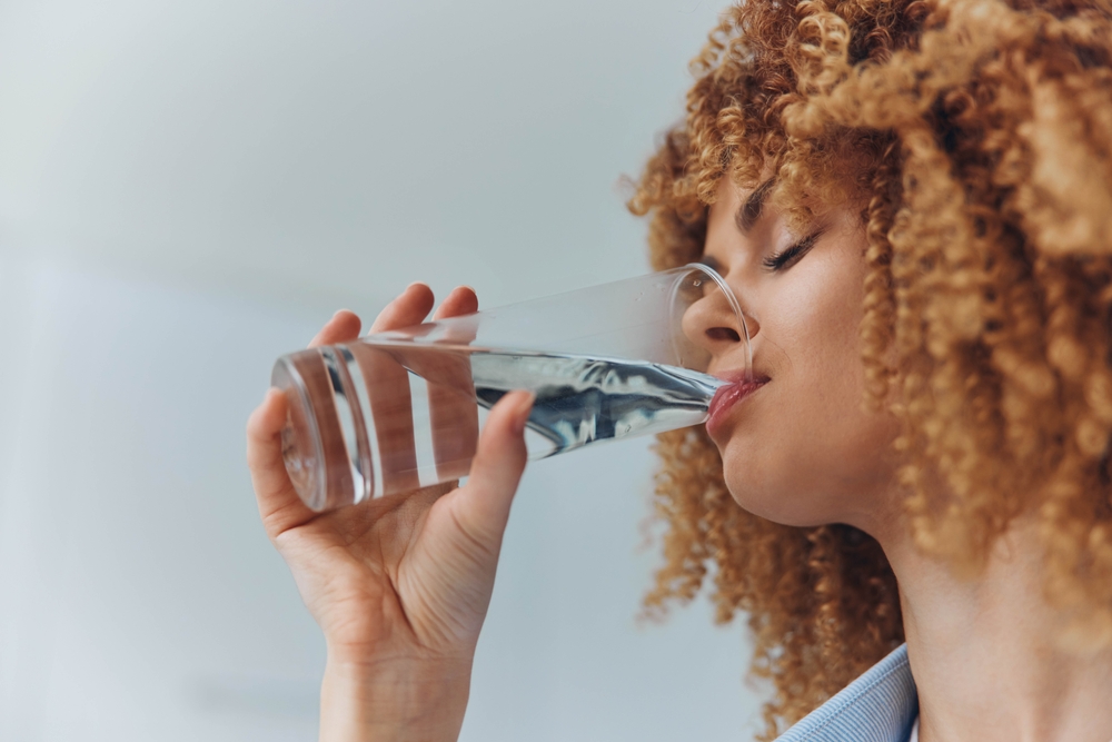 Curly haired woman drinking water